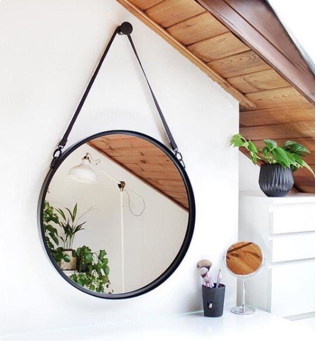 Room with round mirror reflecting plants